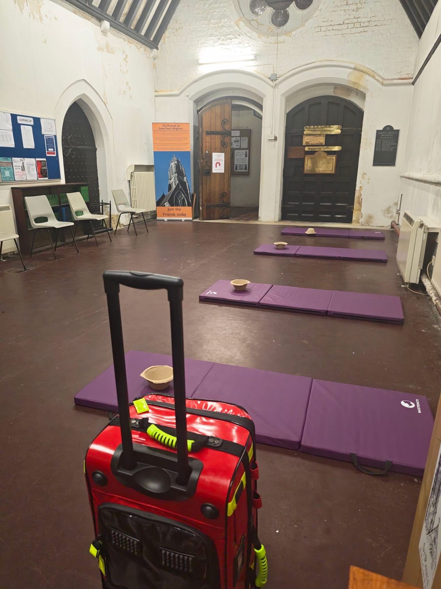 Safe Space before opening, with purple rest mats and a red medical response bag